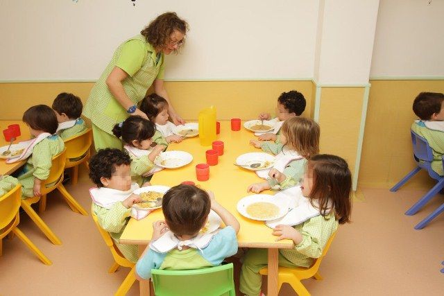 Escuela Infantil Los Robles profesora con niños en comedor